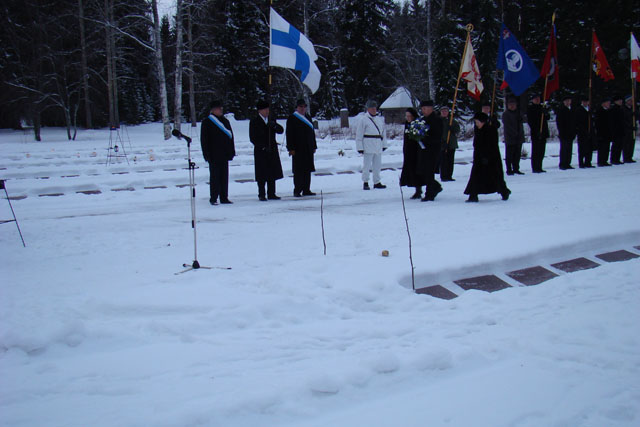 Suomen lippu ja ihmisiä rivissä.